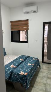 una camera da letto con un letto con un piumone e una finestra di WID appartement a Abidjan