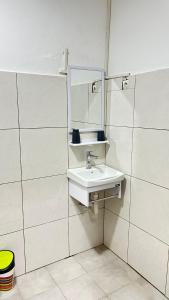un bagno bianco con lavandino e specchio di WID appartement a Abidjan 1 altra foto