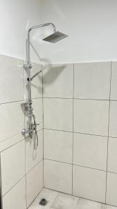 un bagno con doccia e piastrelle bianche di WID appartement a Abidjan