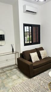 un divano marrone in un soggiorno con finestra di WID appartement a Abidjan