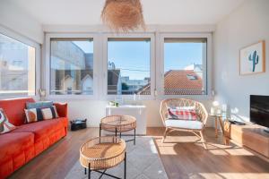 a living room with a red couch and chairs and windows at Les Oiseaux-2 chambres idéalement placé proche plage et centre in Le Touquet-Paris-Plage
