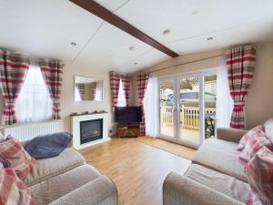 a living room with a couch and a tv at TOM TODDY - Enchanting Golden Sands Caravan at Dawlish Warren in Dawlish Warren
