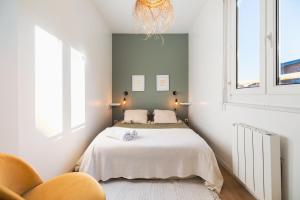 a bedroom with a bed and a chair at Les Oiseaux-2 chambres idéalement placé proche plage et centre in Le Touquet-Paris-Plage