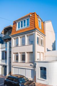 a black car parked in front of a white building at Les Oiseaux-2 chambres idéalement placé proche plage et centre in Le Touquet-Paris-Plage