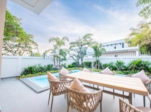 a patio with a table and chairs and a pool at So beach villa pattaya in Jomtien Beach
