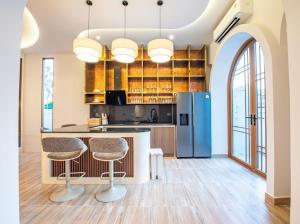 a kitchen with a refrigerator and two bar stools at So beach villa pattaya in Jomtien Beach