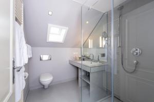 a bathroom with a toilet and a glass shower at Zollhaus 2 in Keitum