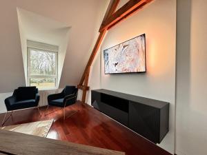 a living room with a flat screen tv on a wall at Villa Nausicaa - Circuit des 24h du Mans - Piscine in Arnage