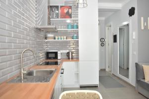 a kitchen with a sink and a brick wall at Wide Beach Apartments 236 in Mullini i Danit