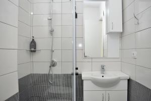 a white bathroom with a sink and a shower at Wide Beach Apartments 236 in Mullini i Danit +21 photos