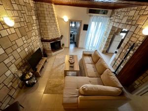 a living room with a couch and a fireplace at Stone House Retreat in Kalavárda +3 photos