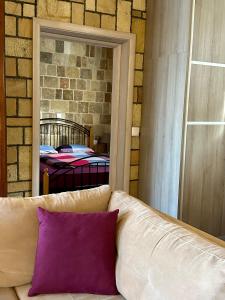 a couch with a purple pillow in front of a mirror at Stone House Retreat in Kalavárda