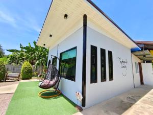 a house with a swing on the front yard at Aroonsri Thara in Ratchaburi