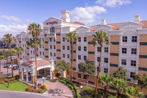 ケープタウンにあるStayEasy Century Cityのヤシの木が前に生えている大きな建物