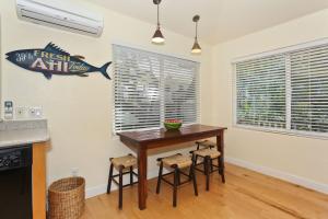 a dining room with a table and stools at The Yellow Cottage in Lanikai Your Perfect Island Getaway! in Kailua