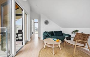 a living room with a green couch and a table at Kysthusene, Lejl 19 in Slagelse