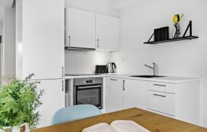 a kitchen with white cabinets and a wooden table at Kysthusene, Lejl 19 in Slagelse