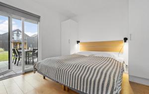 a bedroom with a bed and a balcony with a table at Kysthusene, Lejl 19 in Slagelse +8 photos