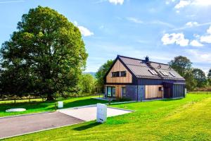 沃拉里Apartmány Na výsluní Šumava - U lípy的草场上一棵树的房子
