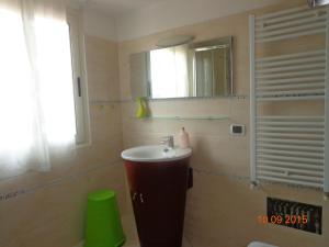 a bathroom with a sink and a mirror at Appartamento Ogliastra in Lanusei