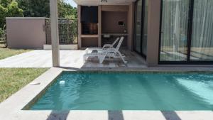 a swimming pool in front of a house at Tierra y Mar - Villas turísticas in Camet Norte