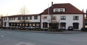 a large white building with cars parked in front of it at Hotel Ellermann in Vlotho