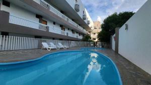 a swimming pool with two chairs and a building at Edificio Mar de Leva in Santa Marta