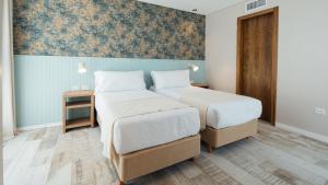 two beds in a room with a wall mural at Tierra y Mar - Villas turísticas in Camet Norte +20 photos