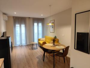 a living room with a table and a yellow couch at Bazan51 1 in Alicante