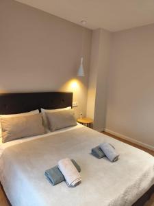 a bedroom with a large bed with two towels on it at Bazan51 1 in Alicante