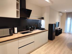 a kitchen with white cabinets and a black refrigerator at Bazan51 1 in Alicante +9 photos