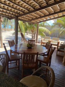 a wooden deck with a table and chairs on the beach at KiteHouseArpoeiras in Acaraú