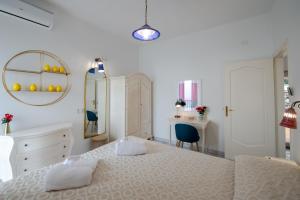 une chambre blanche avec un grand lit et un miroir dans l'établissement Villa Il Lupo Felice, à Ravello
