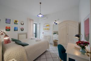 une chambre avec un lit et un bureau et une pièce dans l'établissement Villa Il Lupo Felice, à Ravello