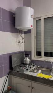a kitchen with a sink and a stove top oven at plateau appartement safi in Safi