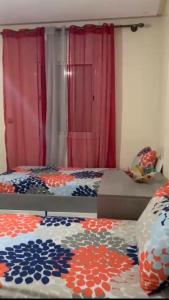 a bedroom with a bed and a red curtain at plateau appartement safi in Safi