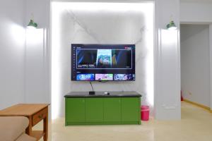 Una sala de estar con un televisor en la pared. en Passion Fruit B&B, en Ruisui