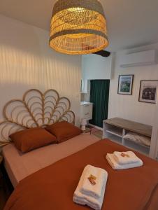 a bedroom with a large bed with towels on it at Charmant studio au coeur de la ville in Guer