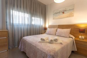 a bedroom with a bed with two towels on it at Calpe Beach in Calpe