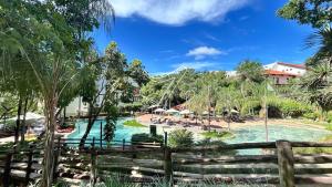 ein Pool in einem Resort mit einem Holzzaun in der Unterkunft Luupi - TURISMO in Rio Quente