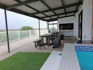 a patio with a table and benches and a swimming pool at Weskusbokkompie in Velddrif