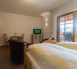 une chambre avec deux lits et une télévision et une fenêtre dans l'établissement Hofbauerngut Sprödhuber, à Passau