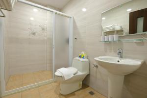 Un baño con inodoro, lavabo y ducha. en Passion Fruit B&B, en Ruisui