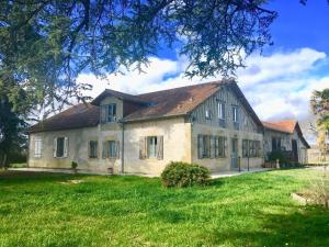 a large house with a grass yard in front of it at Les Cèdres de Nauton in Vergoignan