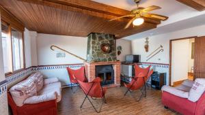 salon z kominkiem i czerwonymi krzesłami w obiekcie Casa Medina de Güevéjar by Ruralidays w mieście Güevéjar