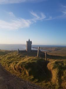 a lighthouse on a hill with the ocean in the background at Coastal Hideaway Pod in Fisherstreet +5 photos