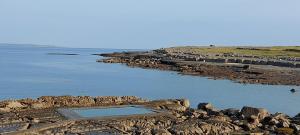 a large pool of water on a rocky shore at Coastal Hideaway Pod in Fisherstreet