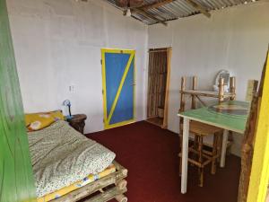 a room with a bed and a table and a yellow door at BiCa Eco-Village in Pokhara