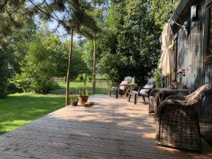 a wooden deck with chairs and a table and chairs at Chalet Het Gewei in Rotsterhaule
