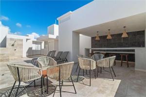 a patio with chairs and a table and a fireplace at Aldea Zama 2-BR Lux Building Amenities in Tulum